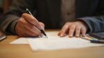 Gros plan sur les mains d'une personne écrivant sur un papier
