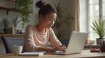 Jeune femme travaillant sur un ordinateur portable dans un intérieur confortable