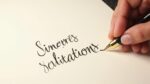 Main écrivant « Sincère Salutation » avec un stylo à encre sur papier blanc